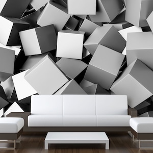 May include: A modern living room setup featuring a white sofa, two ottomans, and a low coffee table. The furniture is set against a wall covered in a 3D geometric pattern of gray and white cubes, creating a striking visual contrast.