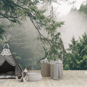 Pode incluir: Uma tenda tipi listrada em preto e branco com estrelas na frente, um brinquedo de rena de pel&uacute;cia e duas cestas de vime com almofadas de padr&otilde;es cinza e branco na frente de um fundo de floresta nebulosa.