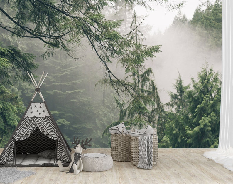 Pode incluir: Uma tenda tipi listrada em preto e branco com estrelas na frente, um brinquedo de rena de pel&uacute;cia e duas cestas de vime com almofadas de padr&otilde;es cinza e branco na frente de um fundo de floresta nebulosa.