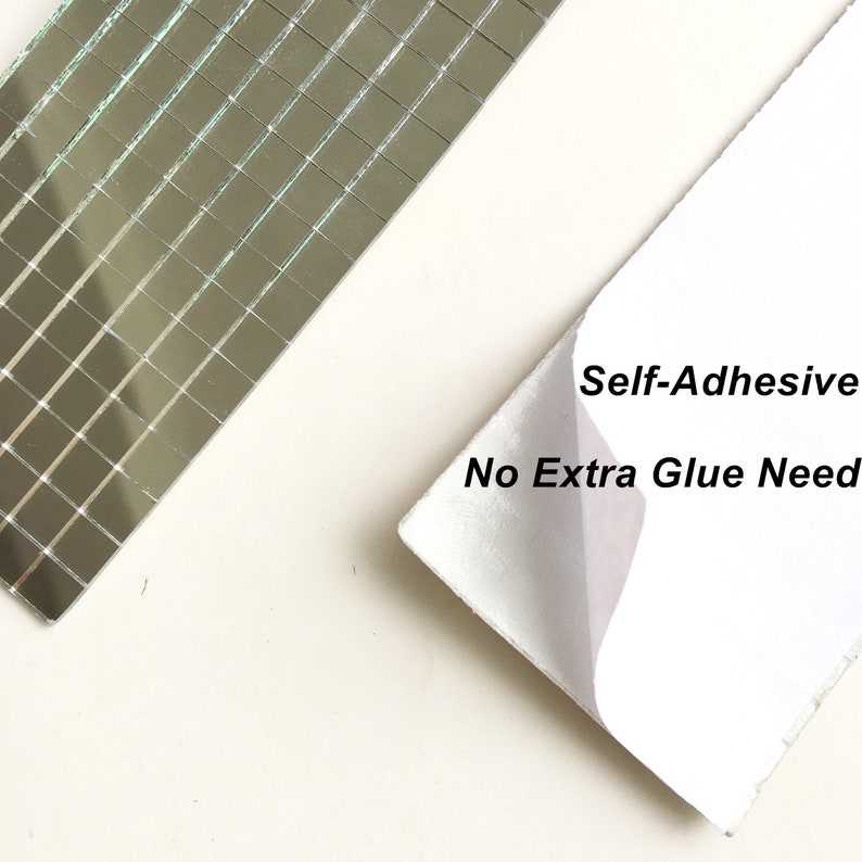 May include: A sheet of self-adhesive mirror tiles. The tiles are small and square, and they are arranged in a grid pattern. The sheet is white and has the text "Self-Adhesive No Extra Glue Need" printed on it.