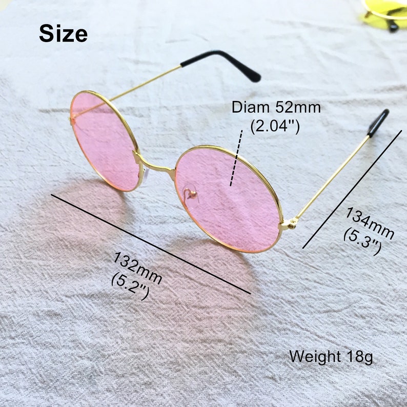 May include: Gold-rimmed round sunglasses with pink lenses. The sunglasses measure 5.2 inches wide and 5.3 inches long. The lenses are 2.04 inches in diameter. The sunglasses weigh 18 grams.
