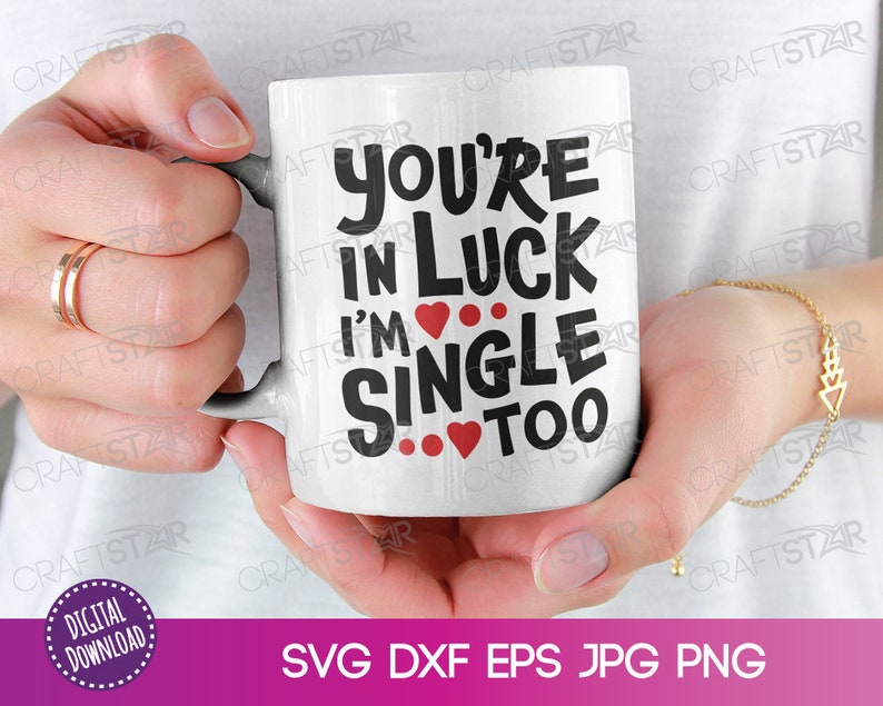 Op de afbeelding: Een witte keramische mok met zwarte tekst die "You're in luck I'm single too" zegt met rode harten.