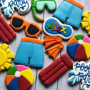 May include: A set of ten decorated sugar cookies with a pool party theme. The cookies are decorated with various summer-themed designs, including a pool float, a beach ball, a pair of sunglasses, a pair of swim trunks, a diving mask, a sun, and a sign that says "Pool Party".