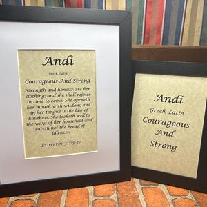 May include: Two framed prints with the name "Andi" and the meaning of the name in Greek and Latin. The larger print includes a quote from Proverbs 31:25-27 about strength and honor.