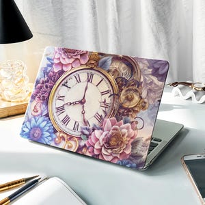 Könnte beinhalten: Eine Laptop-Haut mit einem Vintage-Blumendesign, das ein großes Zifferblatt mit römischen Ziffern zeigt, umgeben von rosa, violetten und blauen Blumen. Das Design erinnert an eine skurrile, märchenhafte Ästhetik.