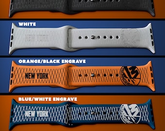 Op de afbeelding: Zes verschillende Apple Watch-bandjes met een New York Islanders-logo, samen met de tekst "New York" en "Islanders". De bandjes zijn verkrijgbaar in wit, zwart, oranje, blauw en twee kleurcombinaties: wit/zwart en blauw/wit.