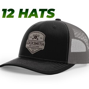 May include: Black and gray trucker hat with a brown patch that says "Locksmith Key Cutting" with a padlock and keys graphic. The patch also says "Premium Quality" and "Est. 1994".