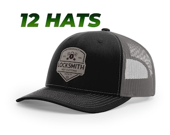 May include: Black and gray trucker hat with a brown patch that says "Locksmith Key Cutting" with a padlock and keys graphic. The patch also says "Premium Quality" and "Est. 1994".