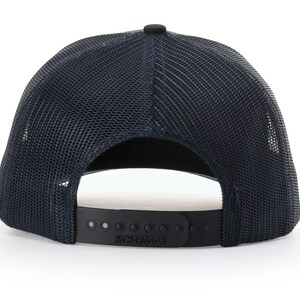 Puede incluir: Una gorra de camionero de malla negra con una correa ajustable negra y la palabra "Richardson" impresa en la correa.