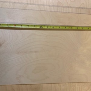May include: A close-up of a light wood sheet with a measuring tape across the top. The tape reads 63 inches.
