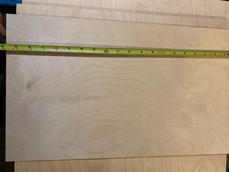 May include: A close-up of a light wood sheet with a measuring tape across the top. The tape reads 63 inches.