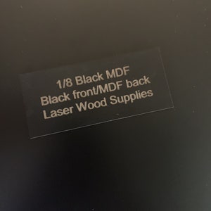 May include: A black label with the text "1/8 Black MDF Black front/MDF back Laser Wood Supplies".