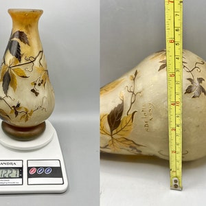 May include: A clear glass vase with a brown and yellow floral design. The vase is 17 inches tall and weighs 1.22 pounds. The vase has the text "Daum Nancy" on the side.