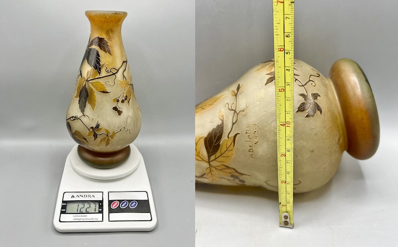 May include: A clear glass vase with a brown and yellow floral design. The vase is 17 inches tall and weighs 1.22 pounds. The vase has the text "Daum Nancy" on the side.