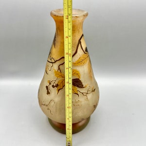 May include: A clear glass vase with a brown and gold floral design. The vase is approximately 10 inches tall and has a rounded body with a narrow neck. The vase is signed "Gall&eacute; Nancy".