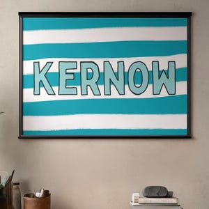 May include: A framed print featuring the word "KERNOW" in light blue block letters with a black outline, set against a backdrop of alternating horizontal stripes of white and turquoise. The artwork is displayed in a black frame.