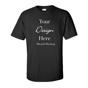 May include: A black short-sleeved t-shirt featuring white printed text on the chest that reads Your Design Here and MiracleMockup. The garment has a crew neckline and a standard fit, presented as a blank template for custom graphic placement.