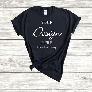 K&ouml;nnte beinhalten: Ein schwarzes T-Shirt mit dem Text "YOUR Design HERE Miraclemockup" auf der Vorderseite.