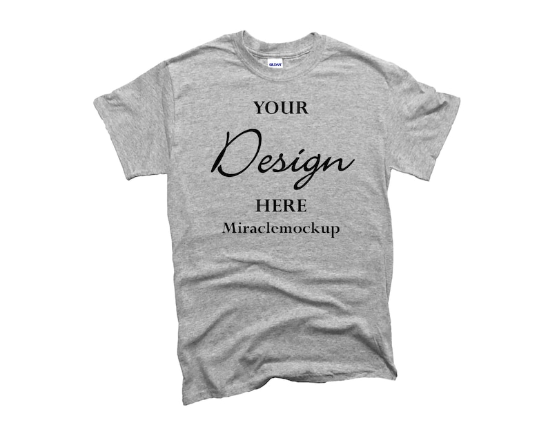 May include: A heather gray t-shirt with the words "YOUR Design HERE Miraclemockup" printed in black. The shirt is a crew neck style and appears to be made of a soft, comfortable material. The shirt is displayed on a white background.