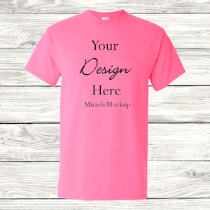 May include: A pink t-shirt with the text "Your Design Here" and "MiracleMockup" printed on the front.