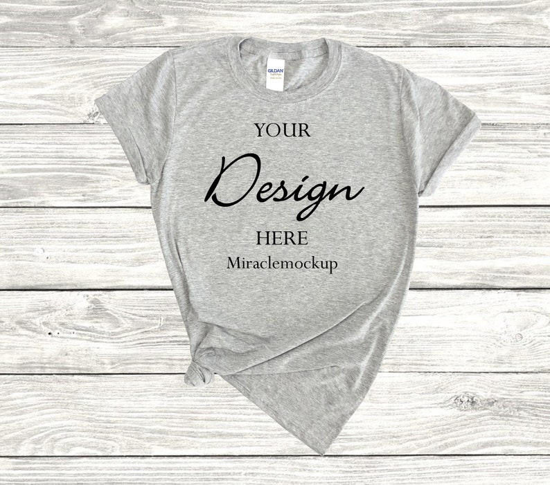 K&ouml;nnte beinhalten: Ein graues T-Shirt mit dem Text "YOUR Design HERE Miraclemockup" auf der Vorderseite.