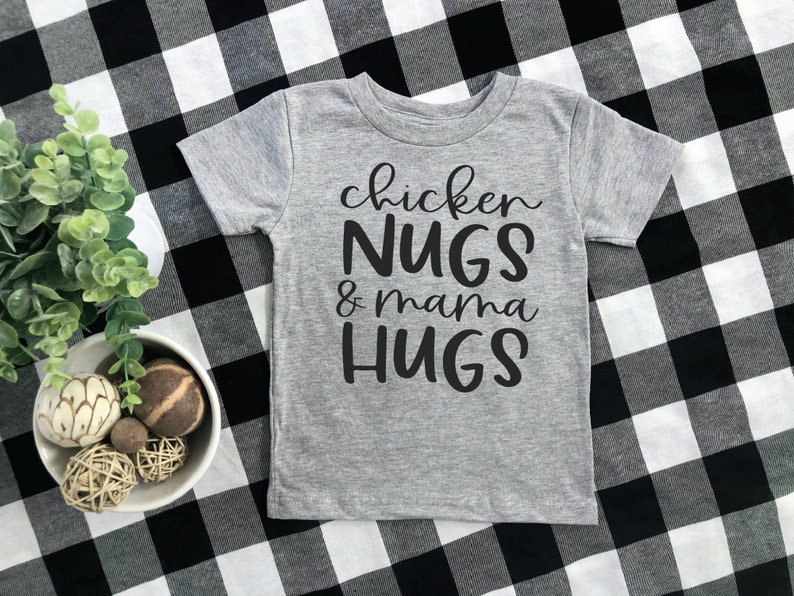 May include: A gray short-sleeved t-shirt with black text that reads "chicken NUGS & mama HUGS".