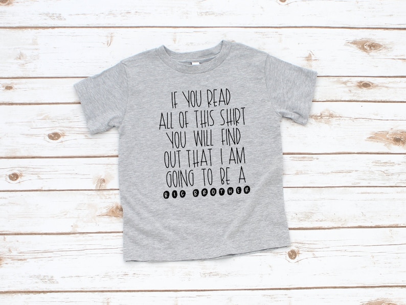 May include: Gray t-shirt with black text that reads "If you read all of this shirt you will find out that I am going to be a Big Brother."