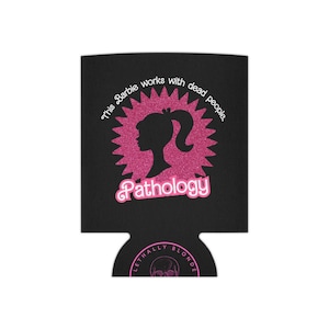 May include: Black can cooler with a pink glitter design featuring a silhouette of a woman's head and the text "This Barbie works with dead people. Pathology."