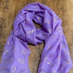 May include: A purple scarf with a gold bunny rabbit pattern.