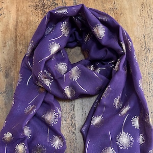 Op de afbeelding: Paarse sjaal met een gouden paardenbloemprint.