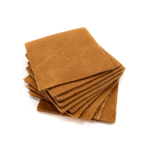 May include: A stack of brown leather squares, likely for crafting or leatherworking projects.