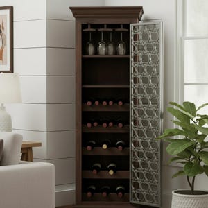 May include: A tall, dark brown wooden wine cabinet featuring a single door with a silver-toned metal overlay in a repeating circular pattern. The interior includes a top rack for hanging stemware and multiple horizontal shelves for wine bottles.