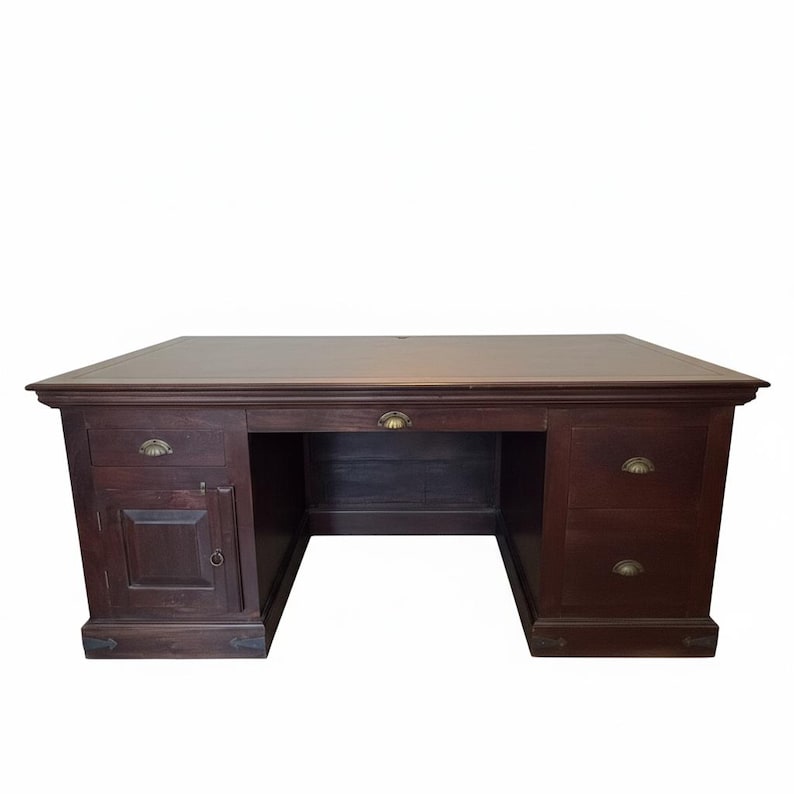 May include: A dark brown wooden desk featuring a rectangular top, a central drawer, and two pedestals. The left pedestal includes one drawer and a cabinet door, while the right pedestal has two drawers. All drawers feature brass shell-shaped pulls.