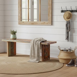 May include: A rustic entryway scene featuring a wooden bench with a blanket, a round jute rug, and a woven basket. A mirror hangs above the bench, and a hat and scarf hang on hooks. The bench has a distressed finish with shades of blue, orange, and brown.