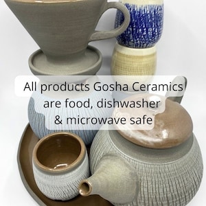May include: A set of gray ceramic teaware, including a teapot, a teacup, a saucer, and a pour-over coffee dripper. All products Gosha Ceramics are food, dishwasher & microwave safe.