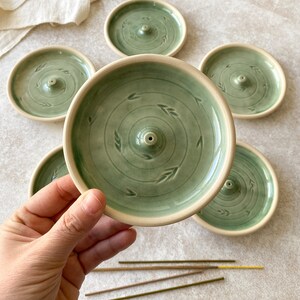 Green round pottery incense holders for cleaning your home.
