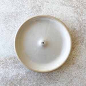 White handmade round ceramic incense holder.