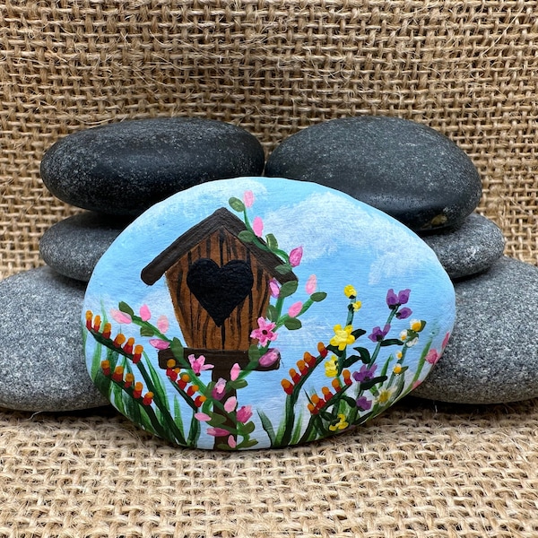 Garden Harmony: Hand-Painted Rock with Wooden Birdhouse Surrounded by Colorful Flowers