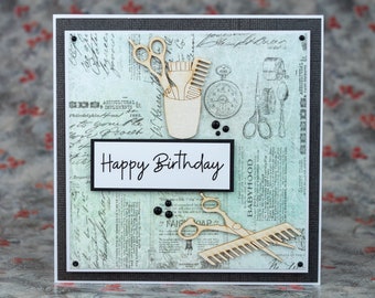 Op de afbeelding: Handgemaakte verjaardagskaart met een kappers thema. De kaart heeft houten uitsparingen van scharen, kammen en een kappersbeker. De woorden "Happy Birthday" staan op een witte rechthoek. De achtergrond heeft een vintage krantenprint.