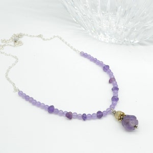 RENEW, Amethyst necklace. Beautiful carved Amethyst Bead, with Carved quartz bead; Sterling Silver caps; faceted, round and nugget amethyst
