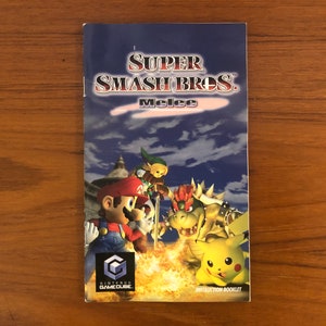 May include: Instruction booklet for the Nintendo GameCube game, Super Smash Bros. Melee. The cover features Mario, Link, Bowser, and Pikachu in a battle scene against a blue sky background. The GameCube logo is visible.