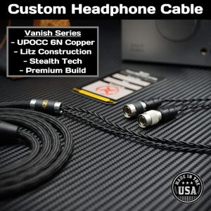 May include: A black headphone cable with silver connectors. The cable is labelled "Vanish Series" and lists features: "UPOCC 6N Copper", "Litz Construction", "Stealth Tech", and "Premium Build". A "Made in the USA" label is in the bottom right corner.