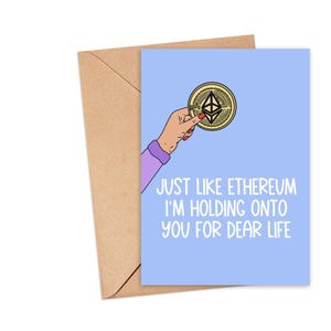 Könnte beinhalten: Eine hellblaue Karte mit einer Hand, die eine goldene Münze mit einem schwarz-weißen Symbol hält. Der Text auf der Karte lautet "Genau wie Ethereum halte ich an dir fest fürs Leben."