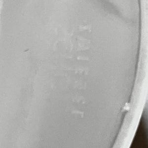 Schott Zwiesel Wine Glasses – Set of 6 – Peachy Grey Iridescent close up of the bottom of the wine glass. etched lightly is the maker name  Schott Zwiesel written backwards as it is likely written on the other side.