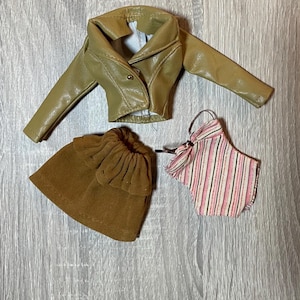 “1960s–70s 1/6 doll outfit with faux leather jacket, suede skirt, and striped top fits Sindy and Blythe.” shown on 1980's Sindy Doll, blonde hair blue eyes. yellow lipstick