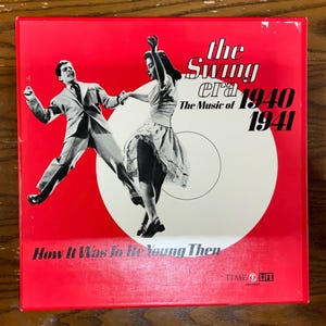 May include: A red album cover with a black and white image of a dancing couple. The text reads "The Swing Era 1940-1941" and "How It Was To Be Young Then". The Time Life Records logo is in the bottom right corner.