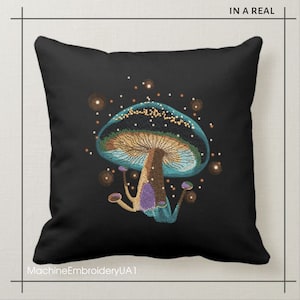 May include: A black pillow with a blue and green embroidered mushroom with a brown stem and purple accents. The mushroom is surrounded by small golden dots.
