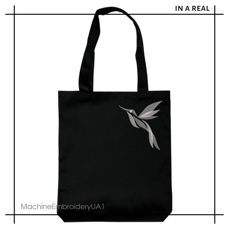 Puede incluir: Bolsa de tela negra con un dise&ntilde;o de colibr&iacute; bordado en blanco. La bolsa tiene dos asas y el texto "MachineEmbroideryUA1" est&aacute; impreso en la parte inferior.