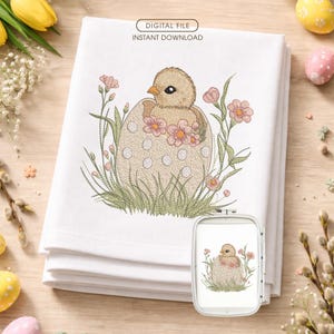 Puede incluir: Toalla de cocina blanca bordada con un pollito saliendo de un huevo, rodeado de flores y hierba. El diseño incluye el texto "DIGITAL FILE INSTANT DOWNLOAD". Una versión más pequeña del diseño está en un bastidor de bordado blanco.