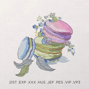 May include: A stack of colourful macarons with a floral design. The macarons are layered in shades of pink, purple, green, and blue. The flowers are a mix of blue and purple.